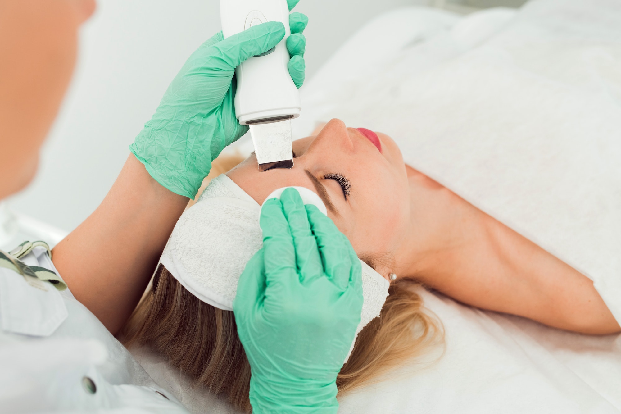 Beautiful woman receiving ultrasound cavitation facial peeling. Cosmetology and facial skin care