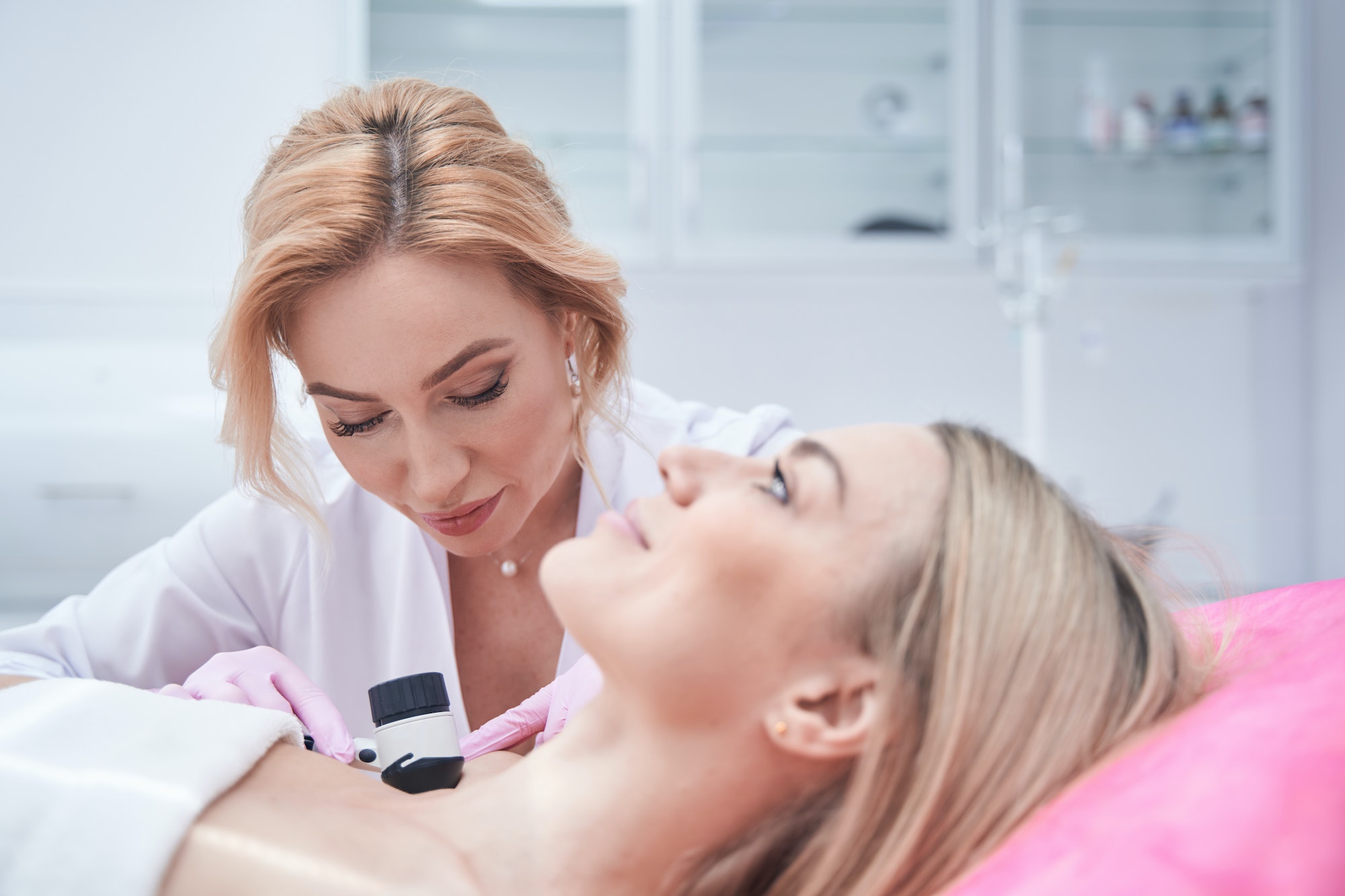 Focused doctor in nitrile gloves performing dermoscopy